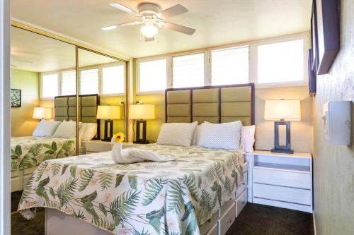 a bedroom with a bed with a swan on it at Hale Ono Loa 114- Ground floor partial ocean view gem in Kahana