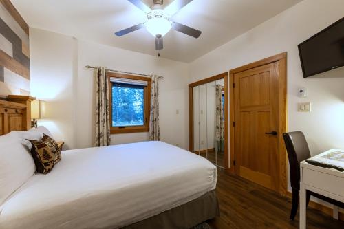 a bedroom with a bed and a desk and a window at Canyon Ridge Lodge in Golden