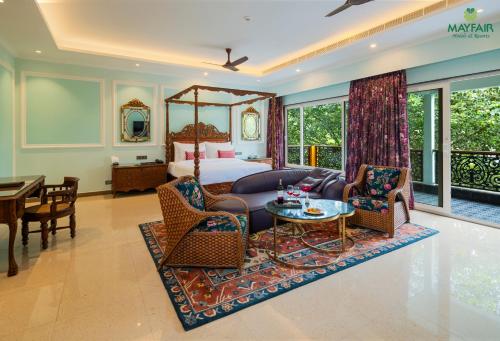 古瓦哈提Mayfair Spring Valley Resort Guwahati的一间带床、桌椅的酒店房间