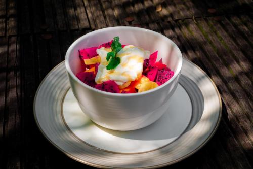 a bowl of food on a plate on a table at Padangan Lodge By Bali Cabin in Padangan