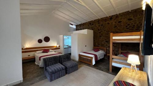 1 dormitorio con 2 camas, sofá y silla en Villas de Cieneguilla, en Cieneguilla