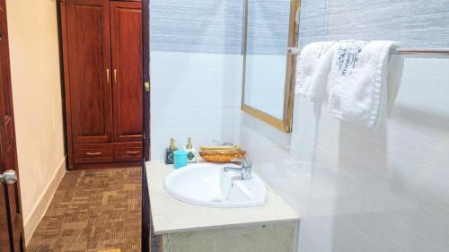 Baño blanco con lavabo y espejo en Khách sạn Hương Thầm Tây Ninh, en Tây Ninh