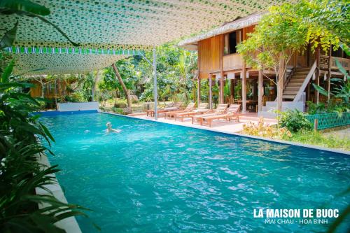 a man swimming in a swimming pool in a resort at La Maison De Buoc in Mai Chau