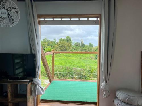 a door to a balcony with a view of a yard at TINY HOUSE avec vues in Capesterre-Belle-Eau