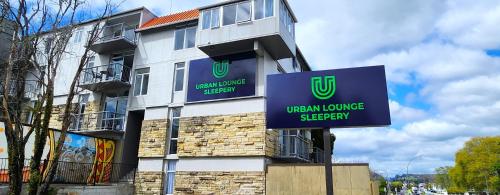 a building with a sign on the side of it at Urban Lounge Sleepery in Rotorua