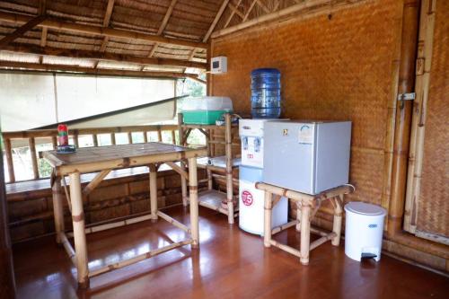 a kitchen with a table and a refrigerator in a room at Kingsacre in Nai Yang Beach