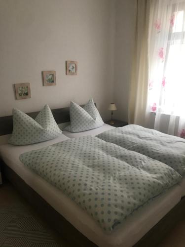 een slaapkamer met een groot bed met witte lakens en kussens bij Ferienwohnung über Greiz in Greiz