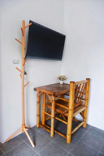 a wooden table with a chair and a tv on a wall at Kingsacre in Nai Yang Beach