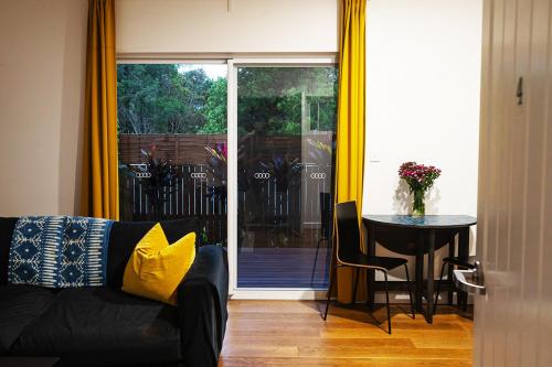 a living room with a couch and a table and a sliding glass door at The Old Church Maleny in Maleny
