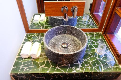 a bathroom counter with a sink and a mirror at De Hué in Hue