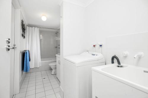 een witte badkamer met een wastafel en een toilet bij Fantastic Beachside Townhouse in Victor Harbor