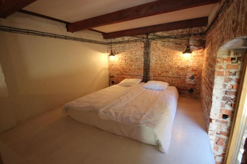 a bed in a room with a brick wall at Karusselli 1 Apartments in Pärnu