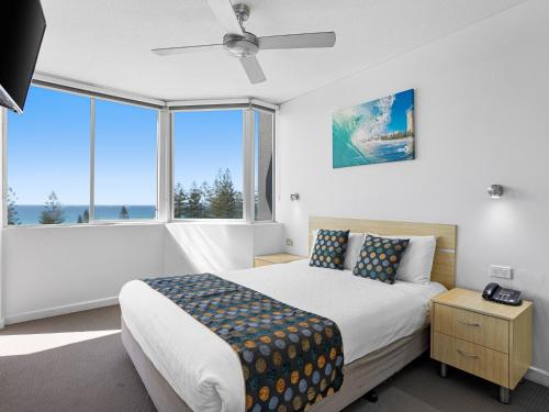 sypialnia z łóżkiem i dużym oknem w obiekcie Mariner Shores Club w mieście Gold Coast