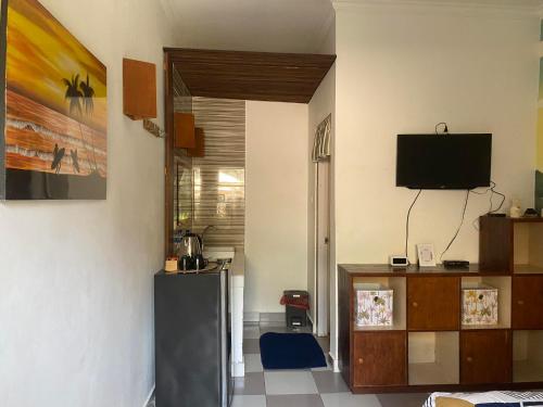 a living room with a refrigerator and a tv at Jasmin Homestay in Sanur