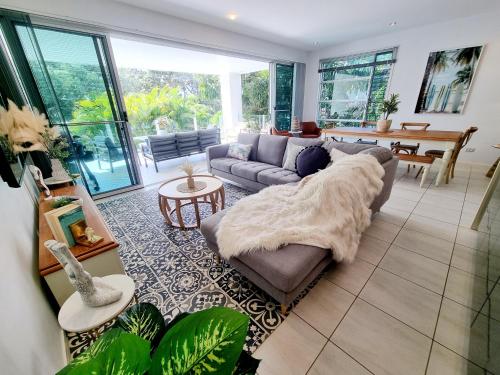 a living room with a couch and a table at Rosalynda- Luxury Beachfront 3 BR Townhouse in Hervey Bay