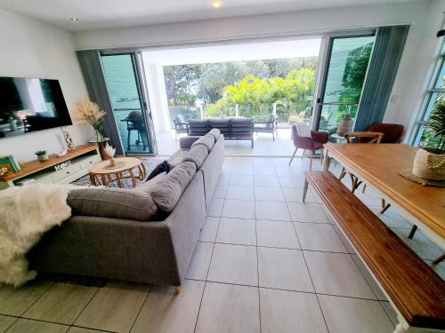 a living room with a couch and a table at Rosalynda- Luxury Beachfront 3 BR Townhouse in Hervey Bay