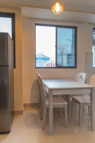 a kitchen with a table and chairs and a window at Fanfini Residence Male’ in Male City