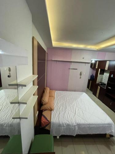 ein kleines Schlafzimmer mit einem Bett und einem Schreibtisch in der Unterkunft Highlander Apartemen Centro City in Jakarta