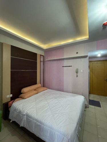 ein Schlafzimmer mit einem großen Bett in einem Zimmer in der Unterkunft Highlander Apartemen Centro City in Jakarta