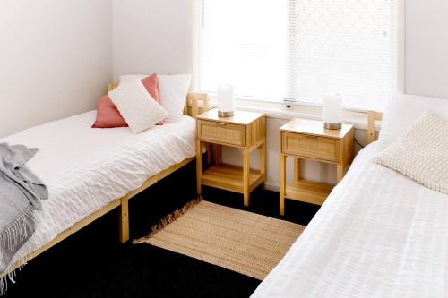 1 dormitorio con 2 camas y una ventana con 2 velas en Spacious Two-Bedroom Retreat, en Ipswich