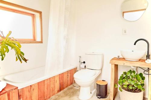 a bathroom with a toilet and a tub and a sink at FARMGLAMP in Balneario Buenos Aires
