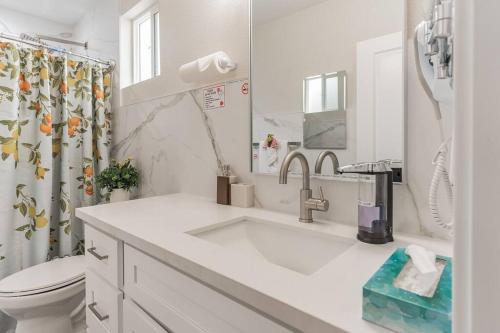 a white bathroom with a sink and a toilet at Family/pet friendly home near Hollywood & Pasadena in Los Angeles