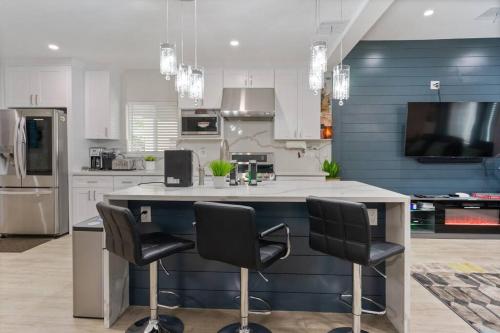 a kitchen with a counter with three chairs in it at LA Home - FIFA Soccer, NBA Games, Universal Studios in Los Angeles
