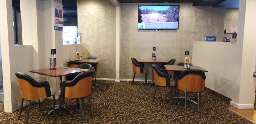 um bar com mesas e cadeiras e uma televisão na parede em Club Hotel Warragul em Warragul