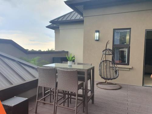 a patio with a table and chairs on a balcony at lovely gated 3 BEDROOM in Kingston