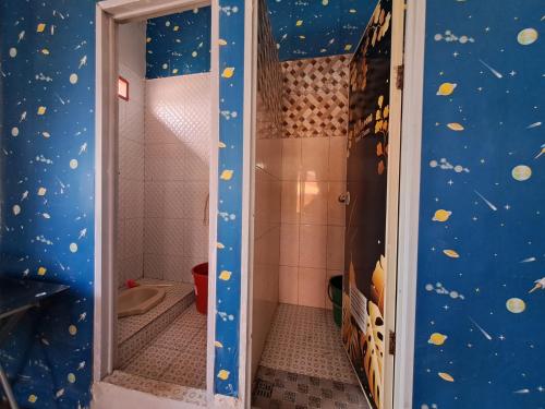 ein Badezimmer mit einer Dusche und einer blauen Wand mit Planeten in der Unterkunft Homestay Setiabudi in Bandung