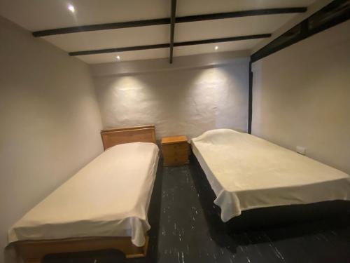 een kleine kamer met 2 bedden bij hosteline in Villa de Leyva