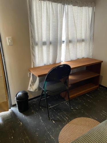 a desk and a chair in front of a window at hosteline in Villa de Leyva