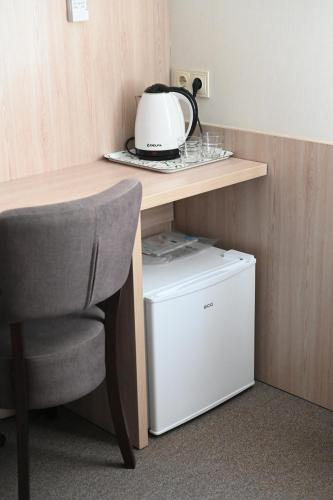 a kitchen with a table and a chair and a refrigerator at 612КМ in Stryi