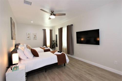 a bedroom with a bed and a flat screen tv at New & Modern with Accessibility-Family Friendly in San Bernardino