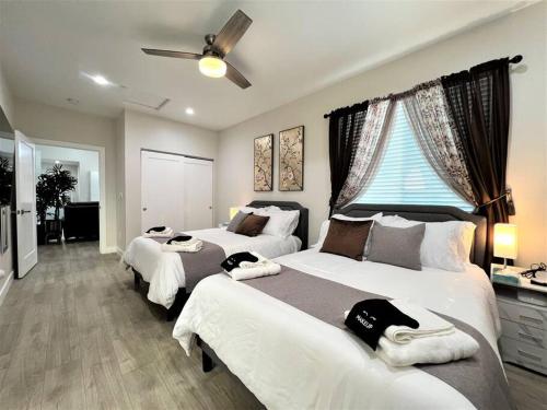 a bedroom with two beds and a ceiling fan at New & Modern with Accessibility-Family Friendly in San Bernardino