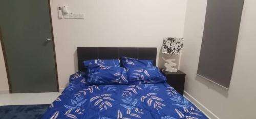 a bed with blue blankets and pillows in a bedroom at TEJAH HOMESTAY in Johor Bahru