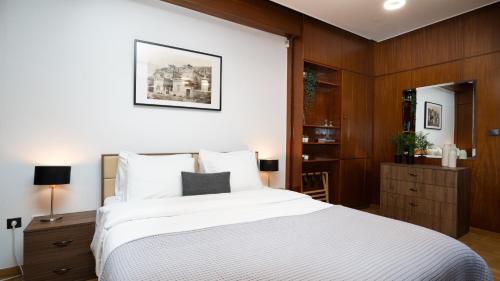 a bedroom with a large white bed and wooden walls at Quiet City Center Apt on a Pedestrian Street in Athens
