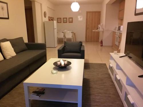 een woonkamer met een bank en een salontafel bij Artemis Panorama Escape Vacation in Tersephanou