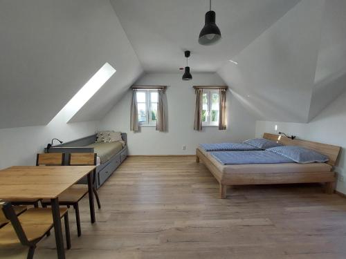 a bedroom with two beds and a wooden table at Apartmány Ema a Ela in Tatranska Strba