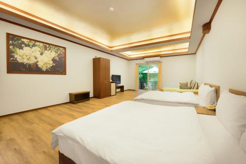 a bedroom with two beds and a painting on the wall at Hui-Lai Resorts in Jianshi