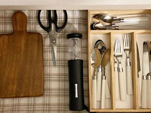 a drawer full of kitchen utensils and a knife at TAB Apartment in Busan