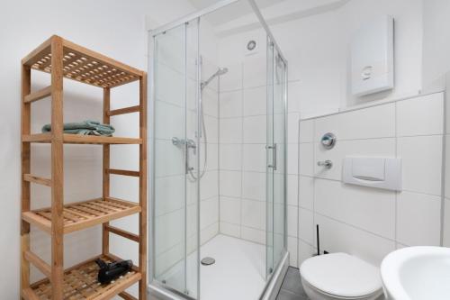 ein Bad mit einer Glasdusche und einem WC in der Unterkunft Chic Apartment with balcony in Wolfsburg