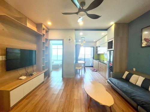 uma sala de estar com um sofá e uma televisão de ecrã plano em Mường Thanh Luxury Viễn Triều Apartment em Nha Trang