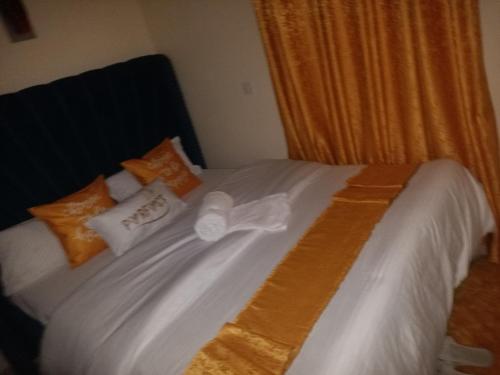 a bed with orange and white pillows on it at DANA HOMES in Nairobi
