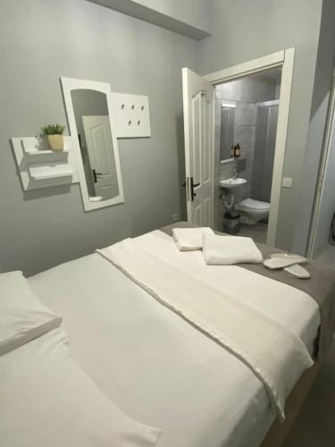 1 Schlafzimmer mit 2 weißen Betten und einem Badezimmer in der Unterkunft Kadıköy Miski Amber in Istanbul