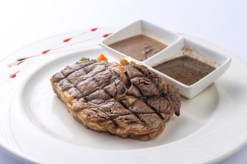 a plate with a steak and a bowl of soup at Hui-Lai Resorts in Jianshi