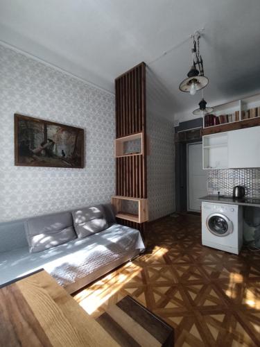 リヴィウにあるКвартира ЛОФТ 2 во Львовеのリビングルーム(ベッド1台付)、キッチンが備わります。