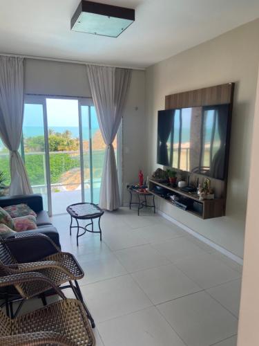 a living room with a tv and a couch at Casa Lofstrom uma luxuosa com linda vista! in Tibau