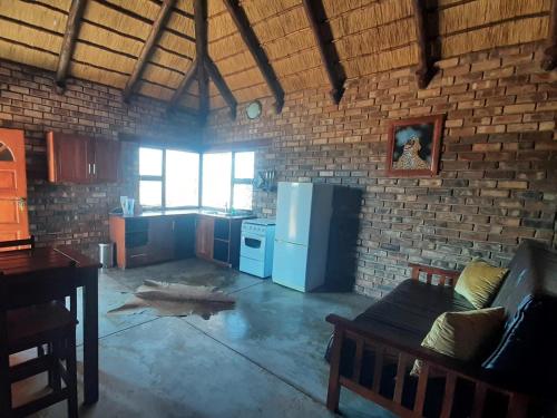 a room with a kitchen with a refrigerator and a table at West Nest Lodge in Gobabis