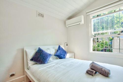 - une chambre avec un lit doté d'oreillers bleus et d'une fenêtre dans l'établissement 3 Bedrooms - Darling Harbour - Ada Place, à Sydney